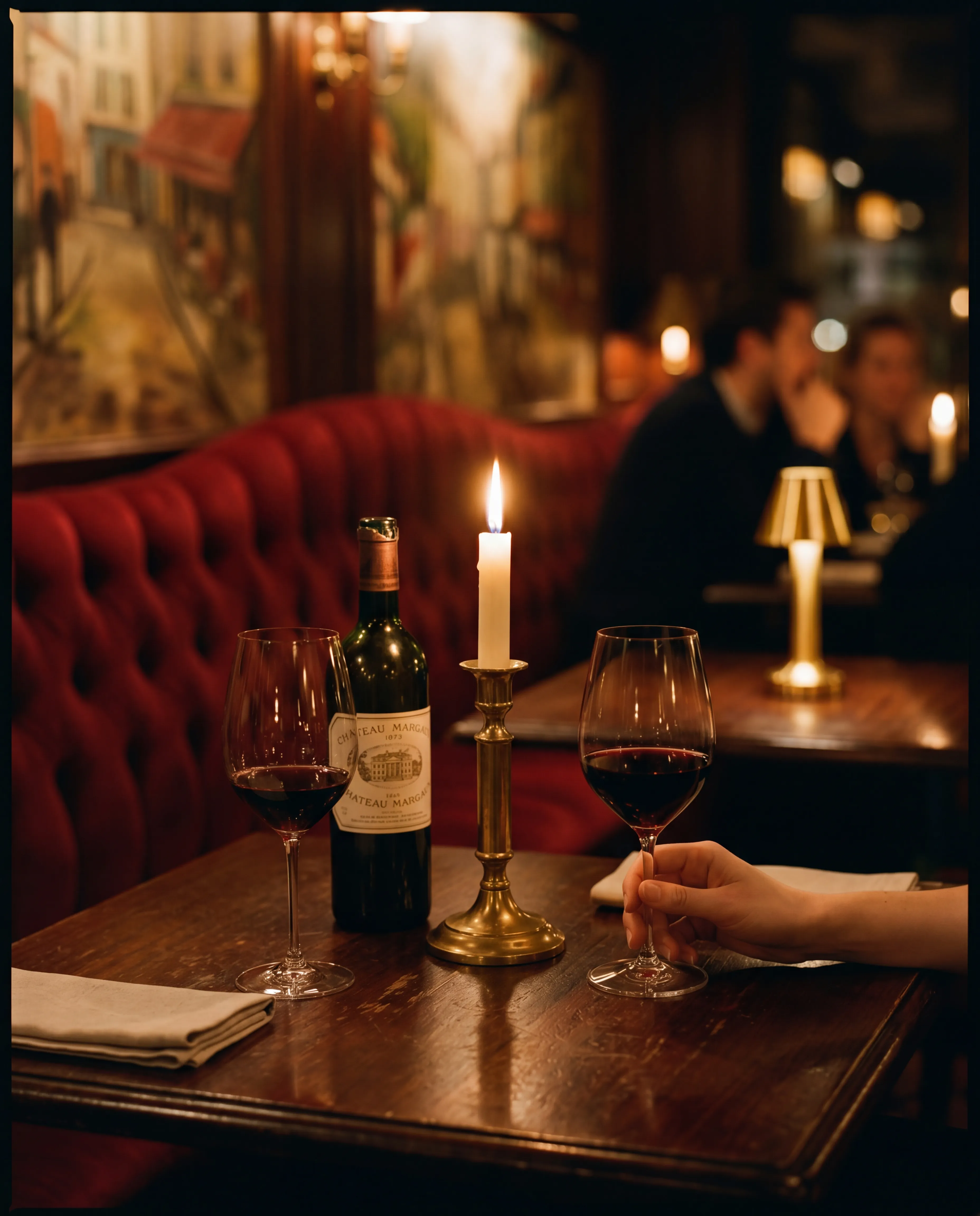 a hand resting on a wine glass in low evening light.